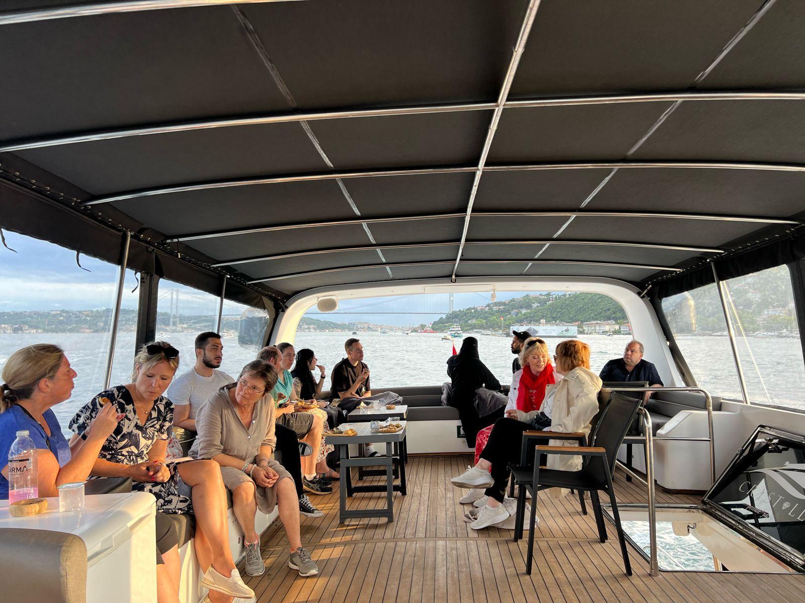 Guests on the open deck watching the sunset over the Bosphorus Bridge from Istanbul